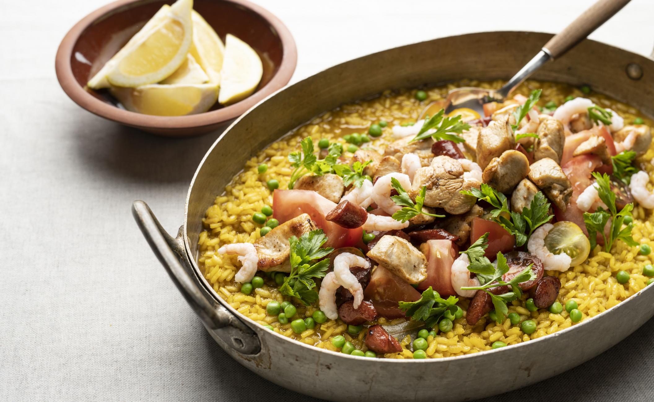 Paella med kylling, chorizo, ærter, persille og rejer