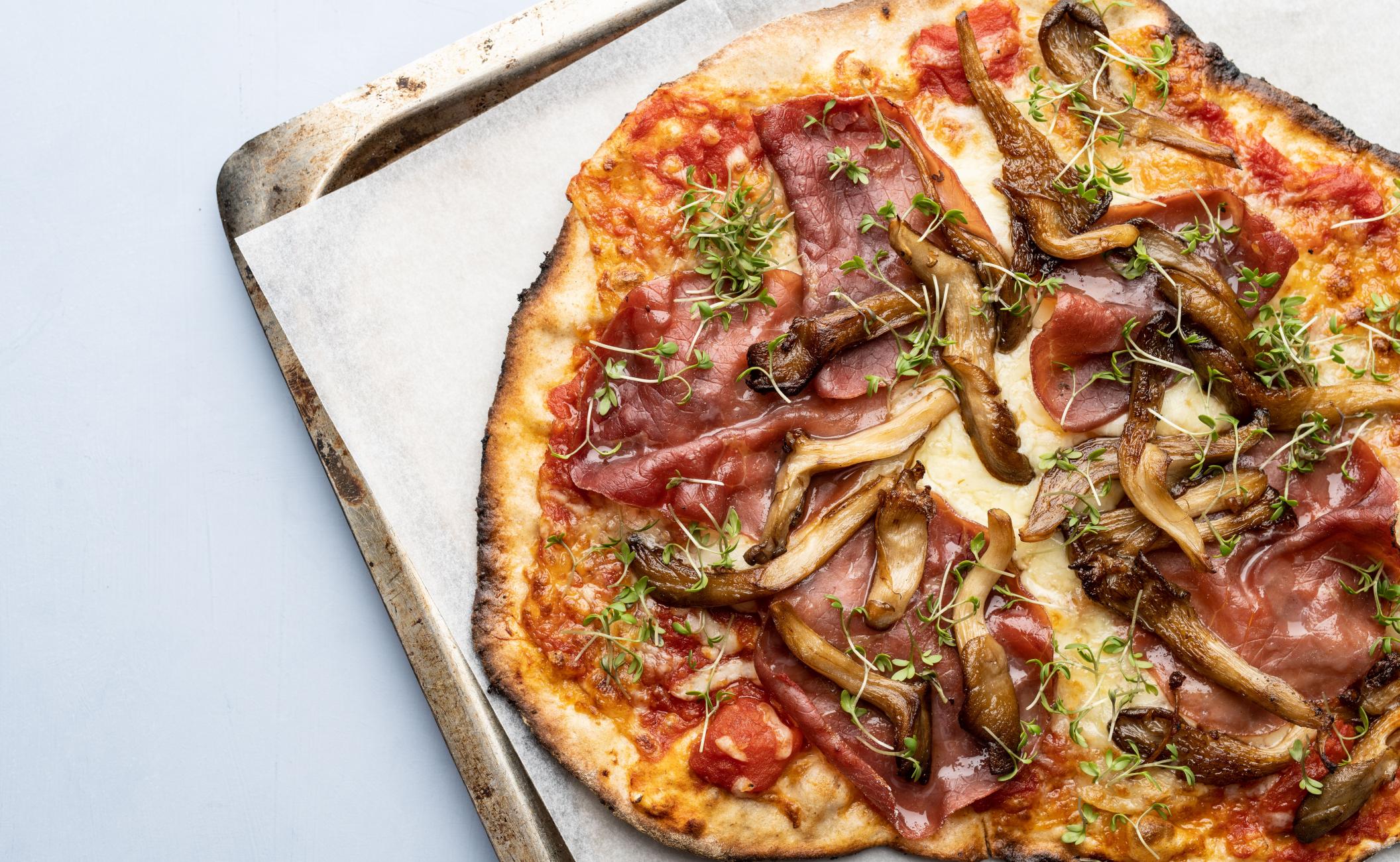 Pizza med tomatsauce, østershatte, bresaola og karse