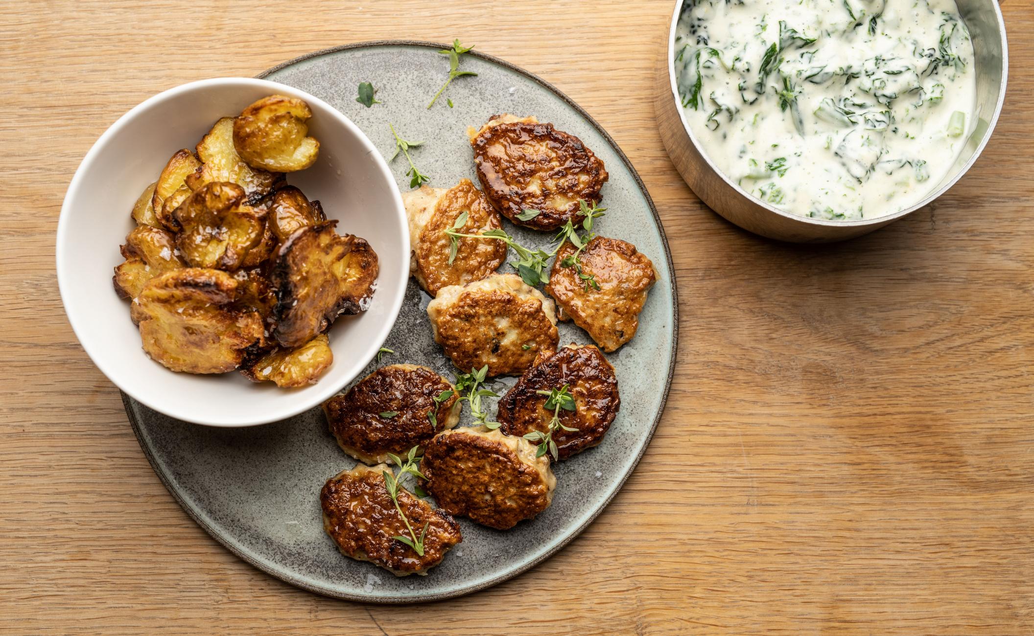 Frikadeller af kylling, æbler og hasselnødder glaseret i honning og dijon og serveret med stuvet grønkål og knuste bagte kartofler