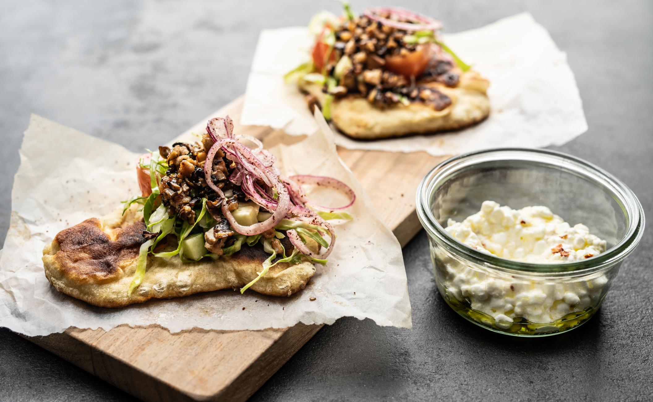 Fladbrød med lynstegt kylling, svampe og agurk, tomat, spidskål og persille i sumak samt hytteostdressing