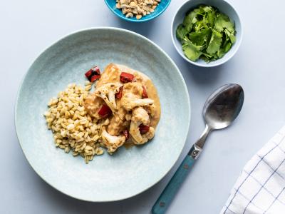 Kylling med blomkål og peberfrugt i jordnøddesauce med kogte hvedekerner og koriander