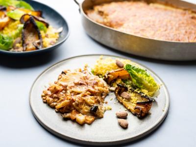 Kartoffelmoussaka med gul couscous, grillet peberfrugt og saltede mandler.